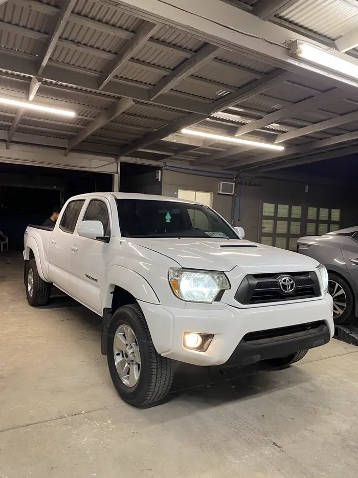 White Toyota Tacoma truck after body repair, parked in the 417 Autoworks shop bay
